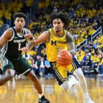 Michigan Wolverines point guard Elliot Cadeau dribbling the basketball