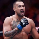 New UFC champion Carlos Ulberg celebrating his title win with a knee injury and lost belt
