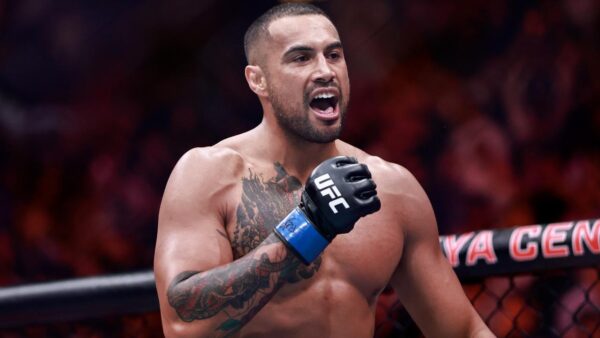 New UFC champion Carlos Ulberg celebrating his title win with a knee injury and lost belt