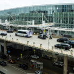 Chicago O'Hare Airport Terminal 5 exterior with health alert overlay for measles exposure warning