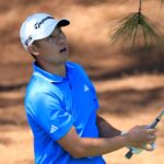 Collin Morikawa playing a shot during the Masters first round, battling mental scars from injury