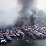 Aerial view of massive fire destroying wooden stilt houses in a Malaysian water village in Sabah
