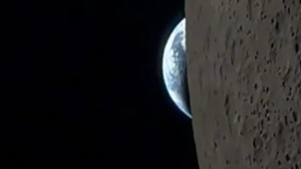 NASA astronaut Reid Wiseman films Earth setting behind the moon from the Orion spacecraft window during Artemis II mission