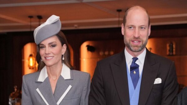 Prince William and Kate Middleton smiling during a public appearance before their three-week royal break