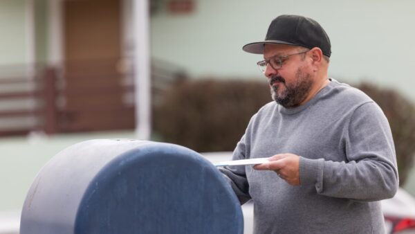 USPS mailbox with tax return envelope showing risk of late filing due to postmark delays